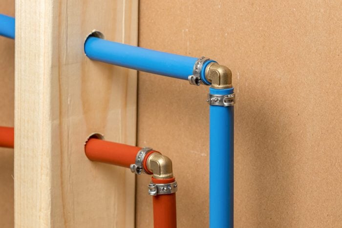 Pex plastic water supply plumbing pipes in wall of house