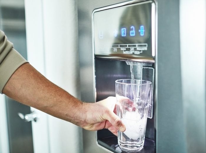 man dispensing water from refrigerator