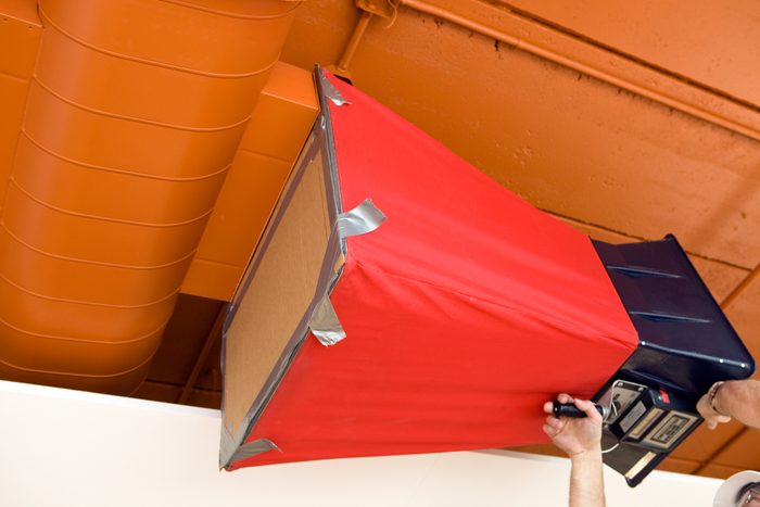 HVAC Worker using an Air Capture Hood Flow Balancer