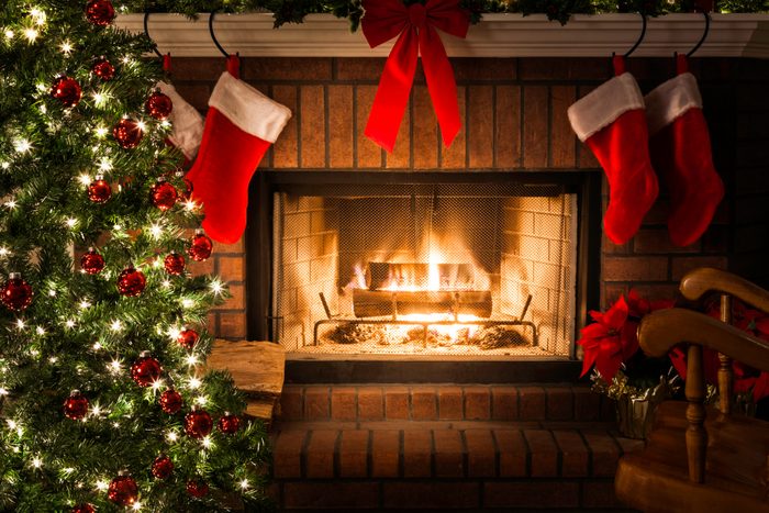 Decorated Christmas tree, blazing fire in fireplace, stockings, rocking chair