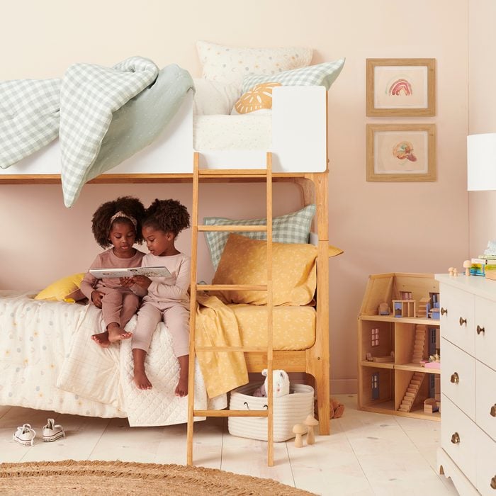 two little girls sitting on bunk beds in little co bedding by lauren conrad