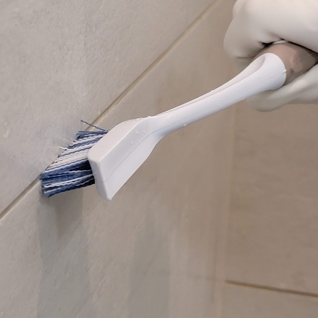 scrubbing tile grout with brush