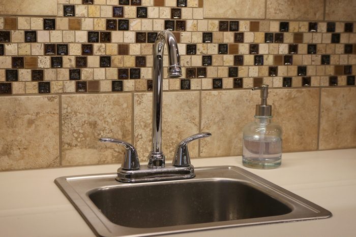 stainless steel Sink with brown tile
