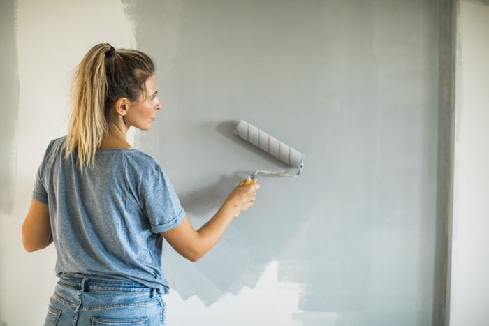 woman painting a wall in her home