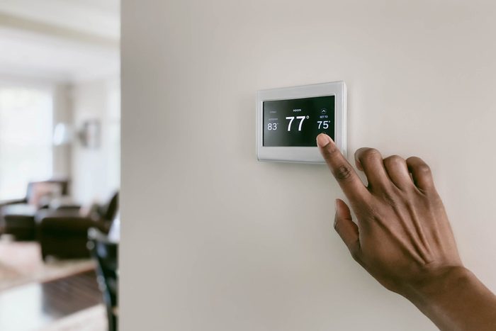 Woman Adjusts Thermostat