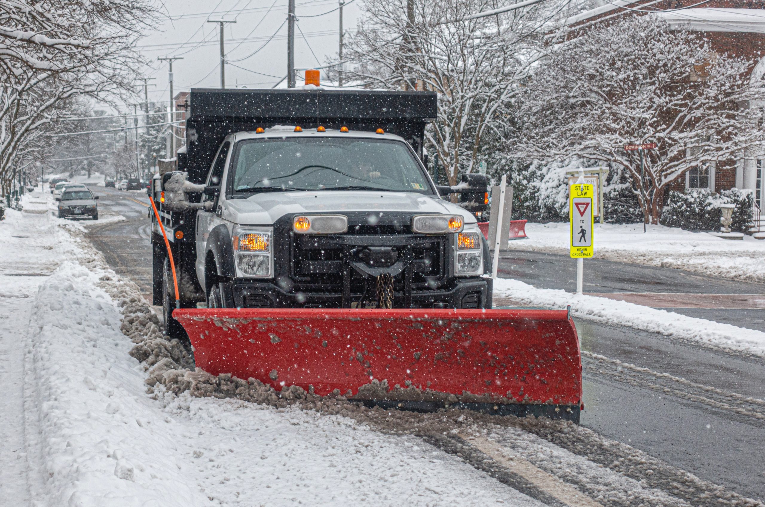 Snowplow Truck Cleaning Road During a Blizzard Snow Storm