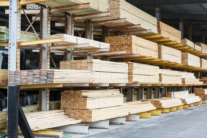 Warehouse at a lumberyard with stacks of construction material on shelves.