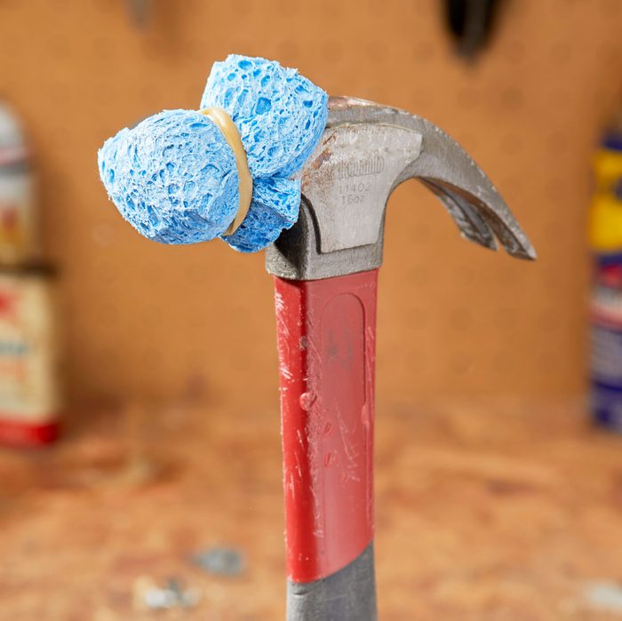 blue sponge secured on the end of a hammer using a rubber band