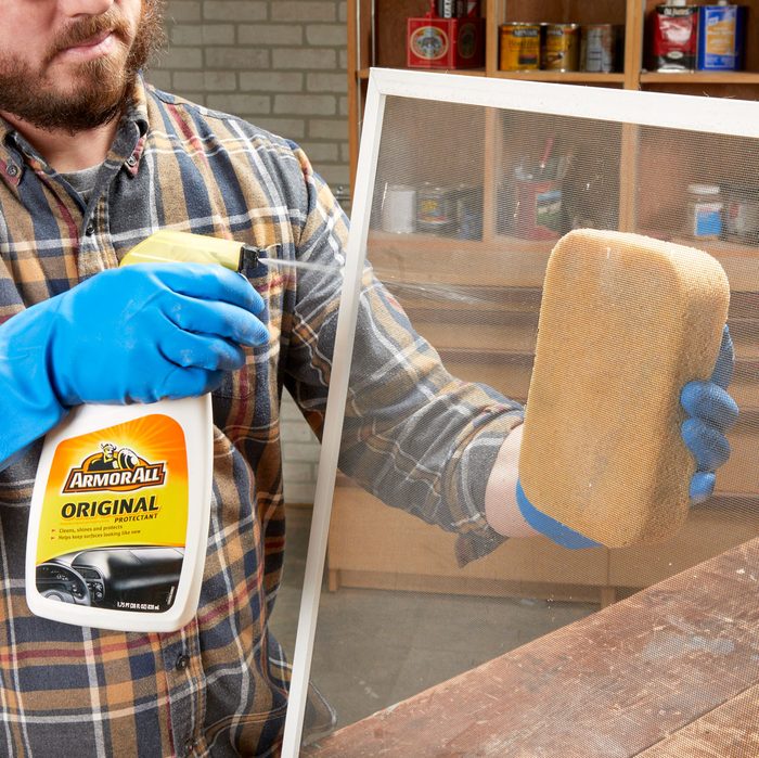 person using armor-all to clean a screen