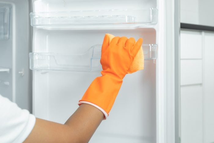 Cropped Hand Of Woman Cleaning Refrigerator