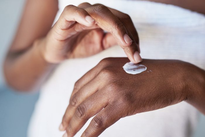 Cropped shot of an unrecognizable woman applying moisturiser to her hands