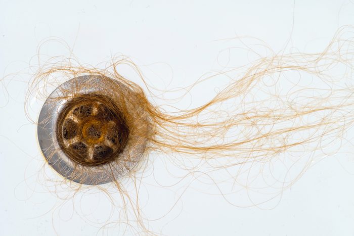 Loose hair in the sink drain in the bathroom after shampooing or showering. The concept of head health problems, deficient conditions in the body due to stress and depression, a consequence of chemotherapy and radiation for cancer.