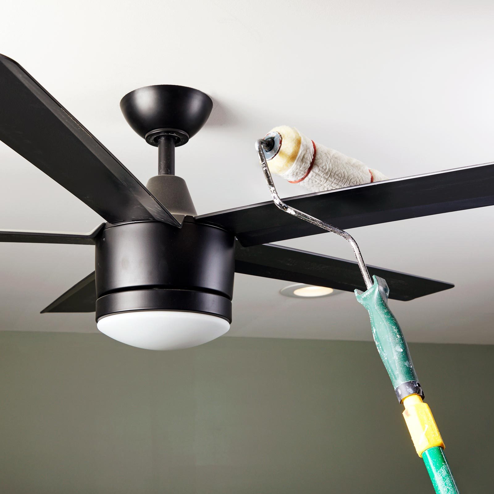 using paint roller to dust off ceiling fan