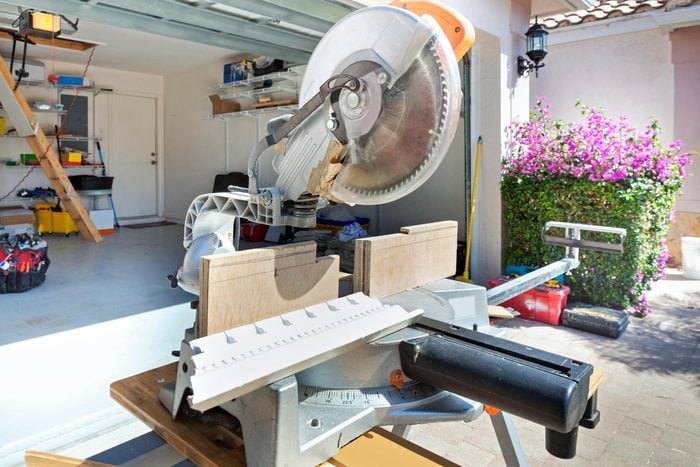 Miter Saw set up in the driveway of a home, in front of an open garage