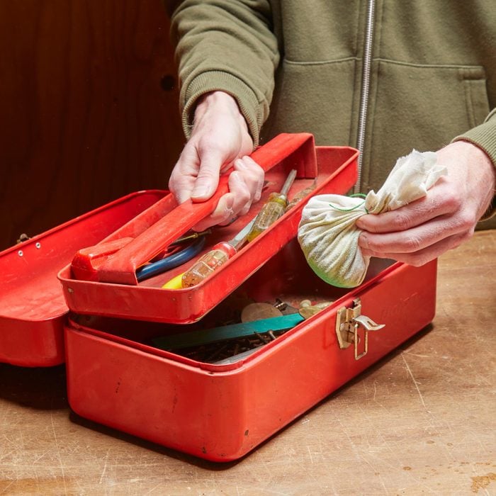 putting a bag of cat litter in a toolbox