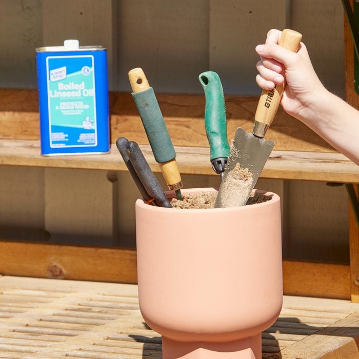 garden tool storage in an outdoor pot filled with sand