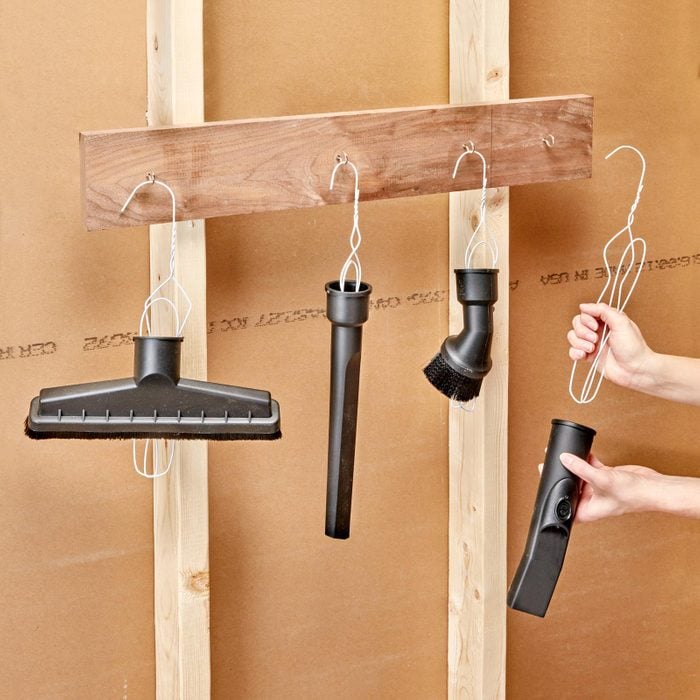 metal hanger organizer in garage for hanging vacuum attachments