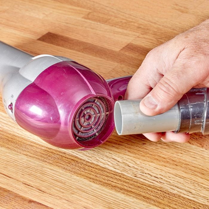 using a vacuum to clean a hair dryer