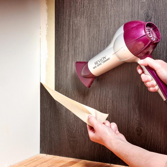 removing adhesives from a wall using a hair dryer