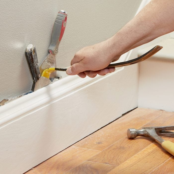 prying baseboard from wall with a pry bar