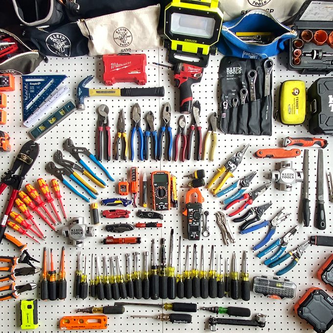 a collection of tools laying on a peg board