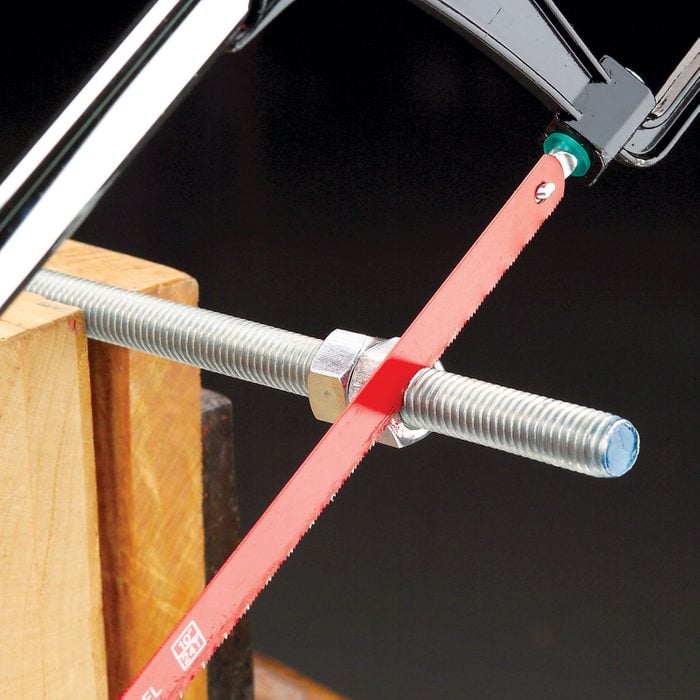 using a hacksaw to cut threaded hardware