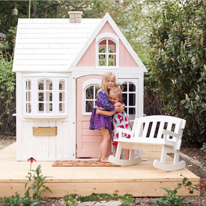pink Playhouse on floating Deck with two hugging girls