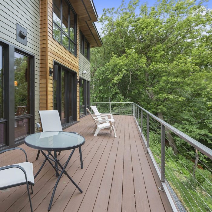 Outdoor wooden balcony deck with modern aluminum and cable railings