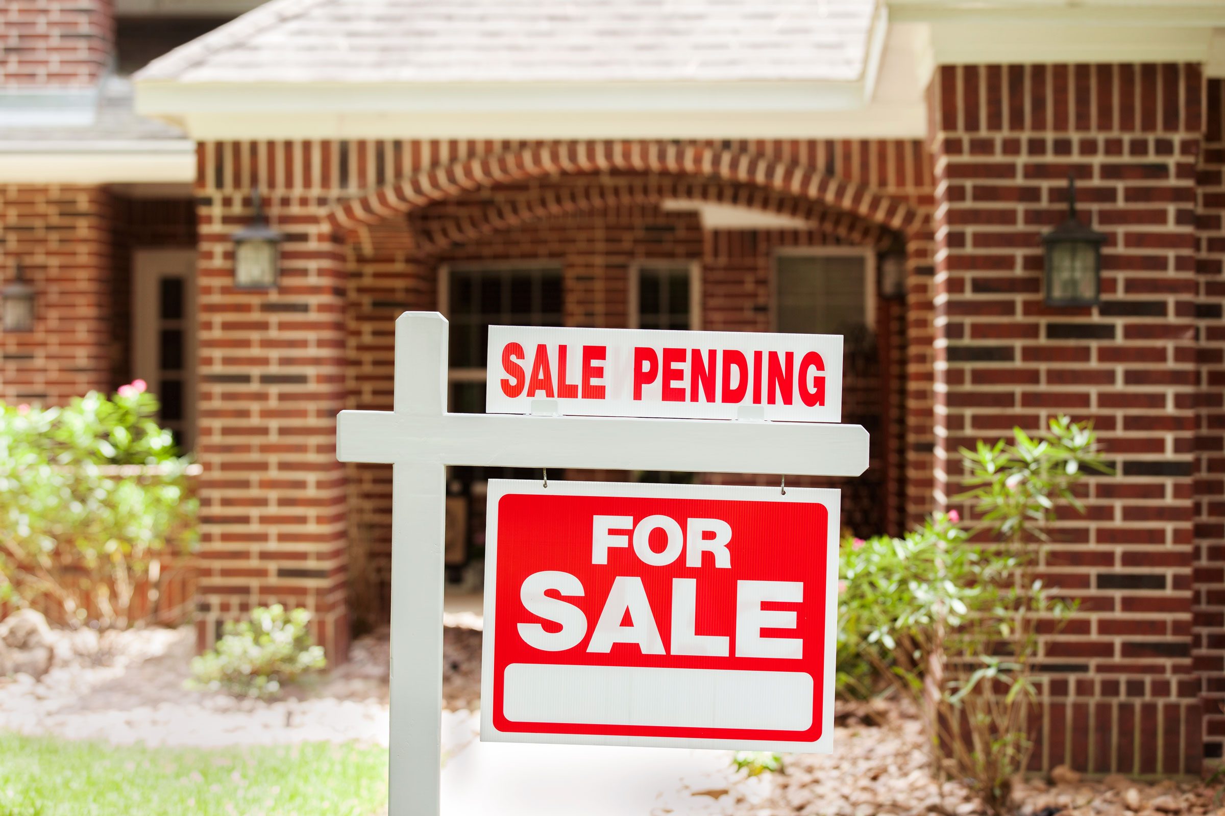 sale pending sign in front of a brick house