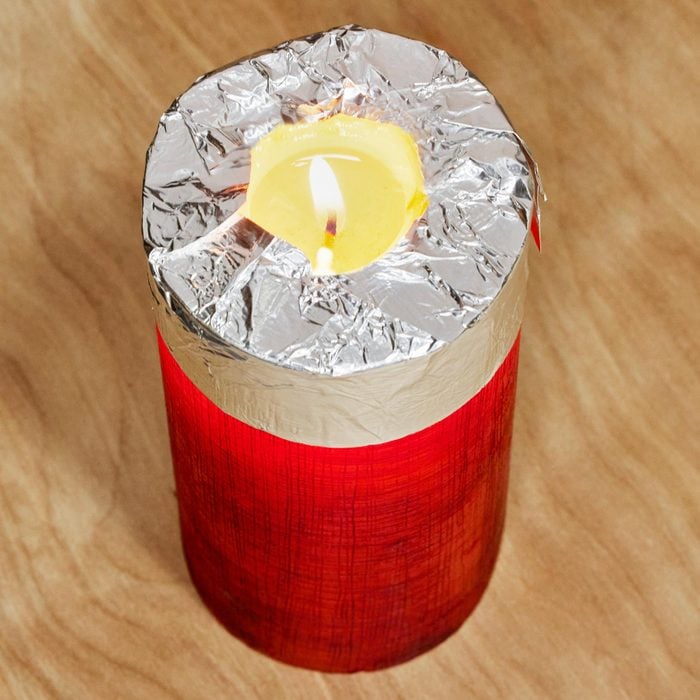 lit candle wrapped with tin foil