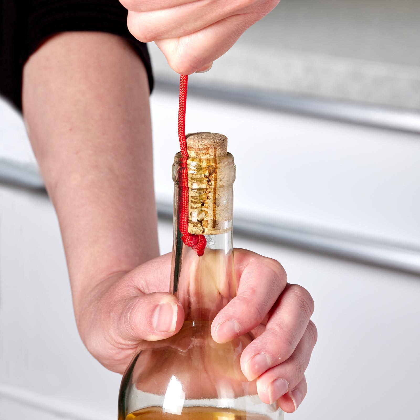 removing a cork from a wine bottle with a piece of string