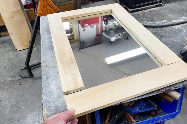 fitting the frame around the mirror