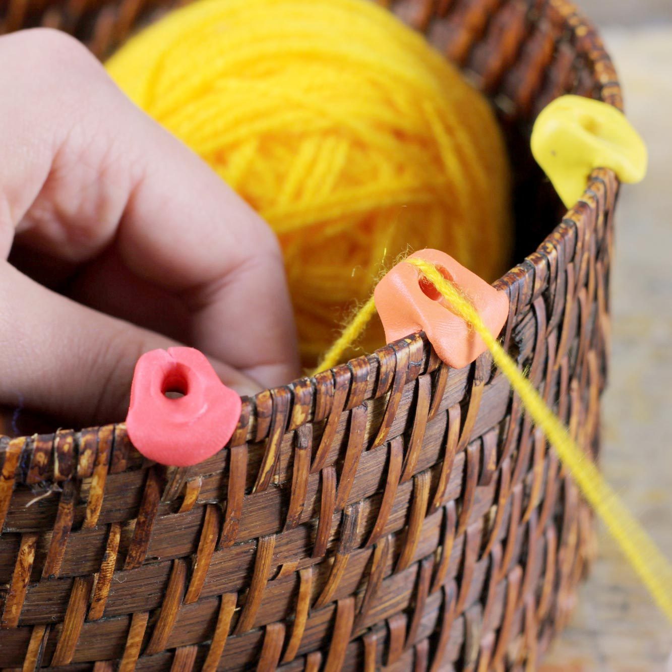 homemade yarn holder on the edge of a basket