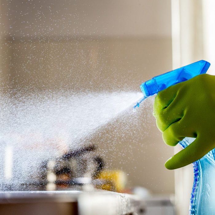 spraying cat detergent onto a kitchen countertop
