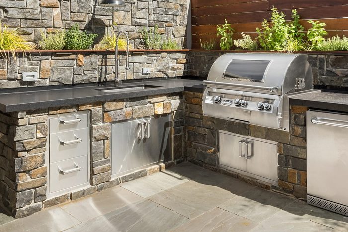 Backyard outdoor kitchen with a grill and sink