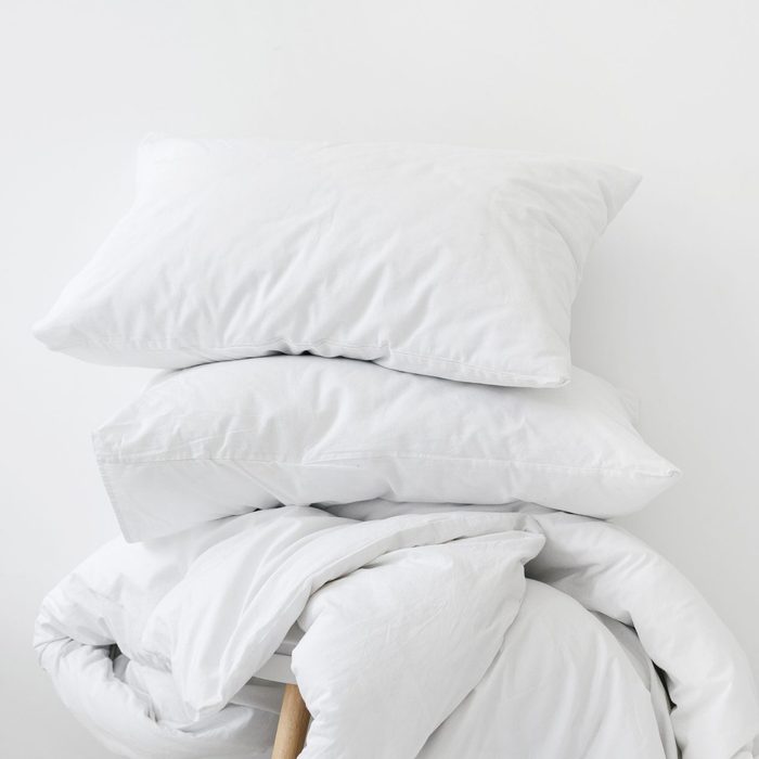 Duvet and pillows against white copy space background