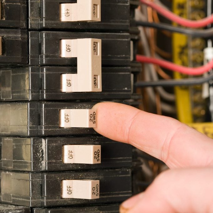 Electrician's Finger Turning On Single-Pole Breaker