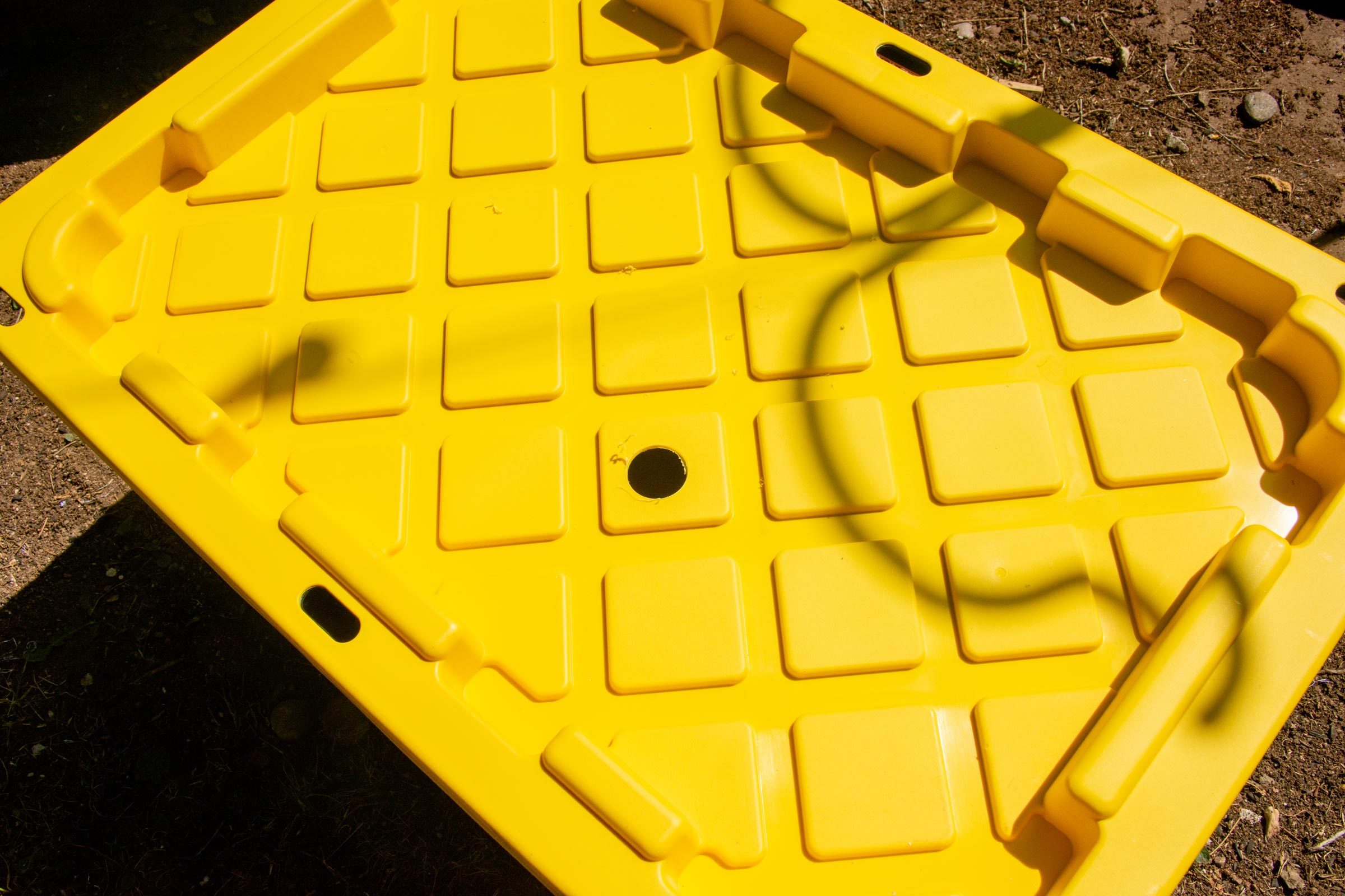 a round hole drilled in the yellow lid of a plastic tote