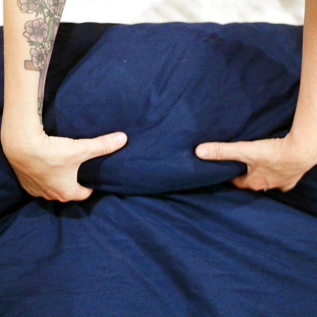 close up of hands unrolling the burrito shaped blue duvet