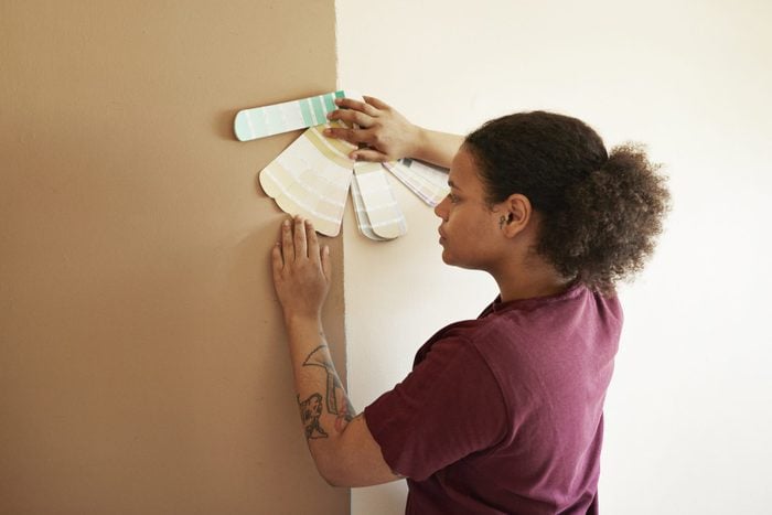 Woman with color swatch against wall