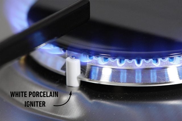 close up of a gas stove and the white porcelain igniter