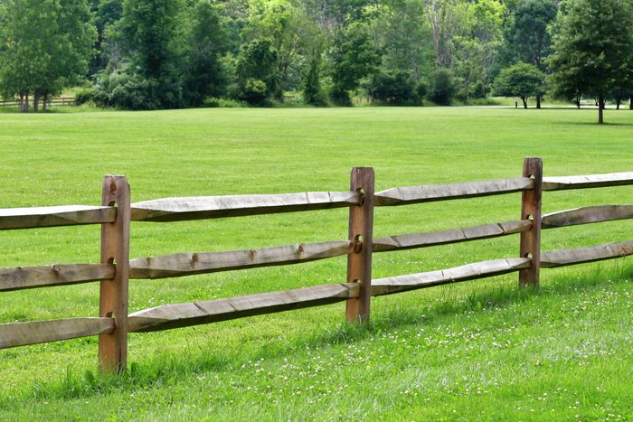 wooden post ranch fence with a large grassy yard
