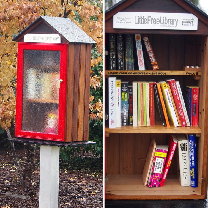 a three shelved little free library painted red with a shelf holding chalk on the inside that's labeled with a sign that says "leave your comments on the roof"