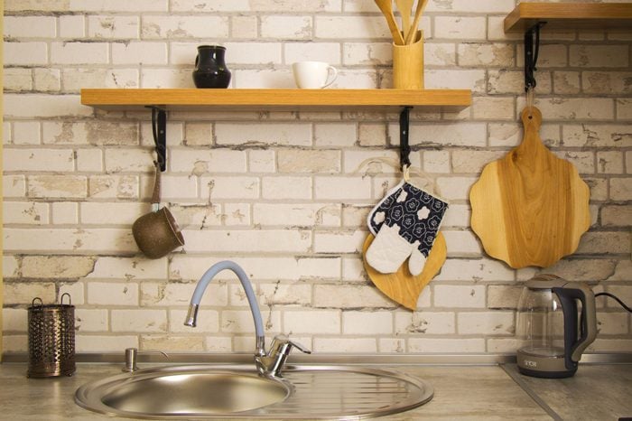 Kitchen Utensils Hanging On Wall At Home