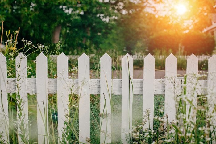 White wooden picket fence at country house backyard