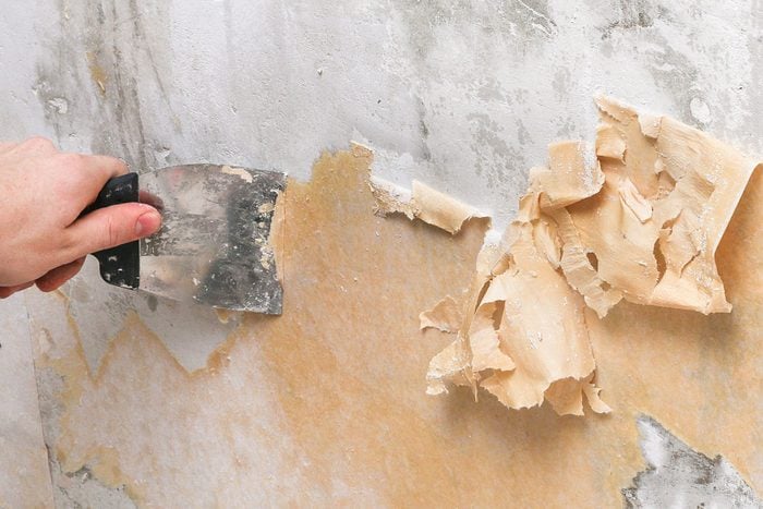 A man removes old wallpaper glue