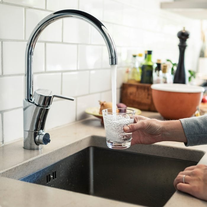 Gettyimages 1316107984 Midsection Of Woman Holding Glass Under Faucet In Kitchen By Kentaroo Tryman