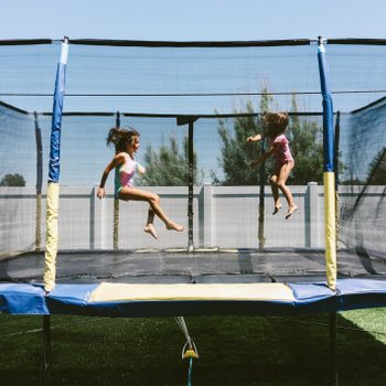 Sisters enjoying summer on the trampoline at home