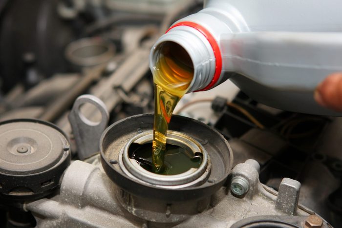 .Car mechanic is changing engine oil