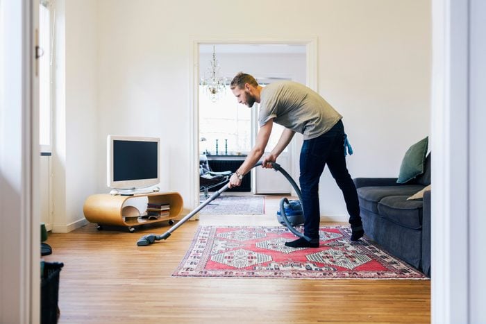 A man vacuuming his home